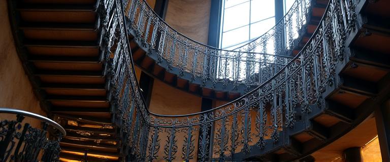 Escalier avec rampe en fer forgé complexe